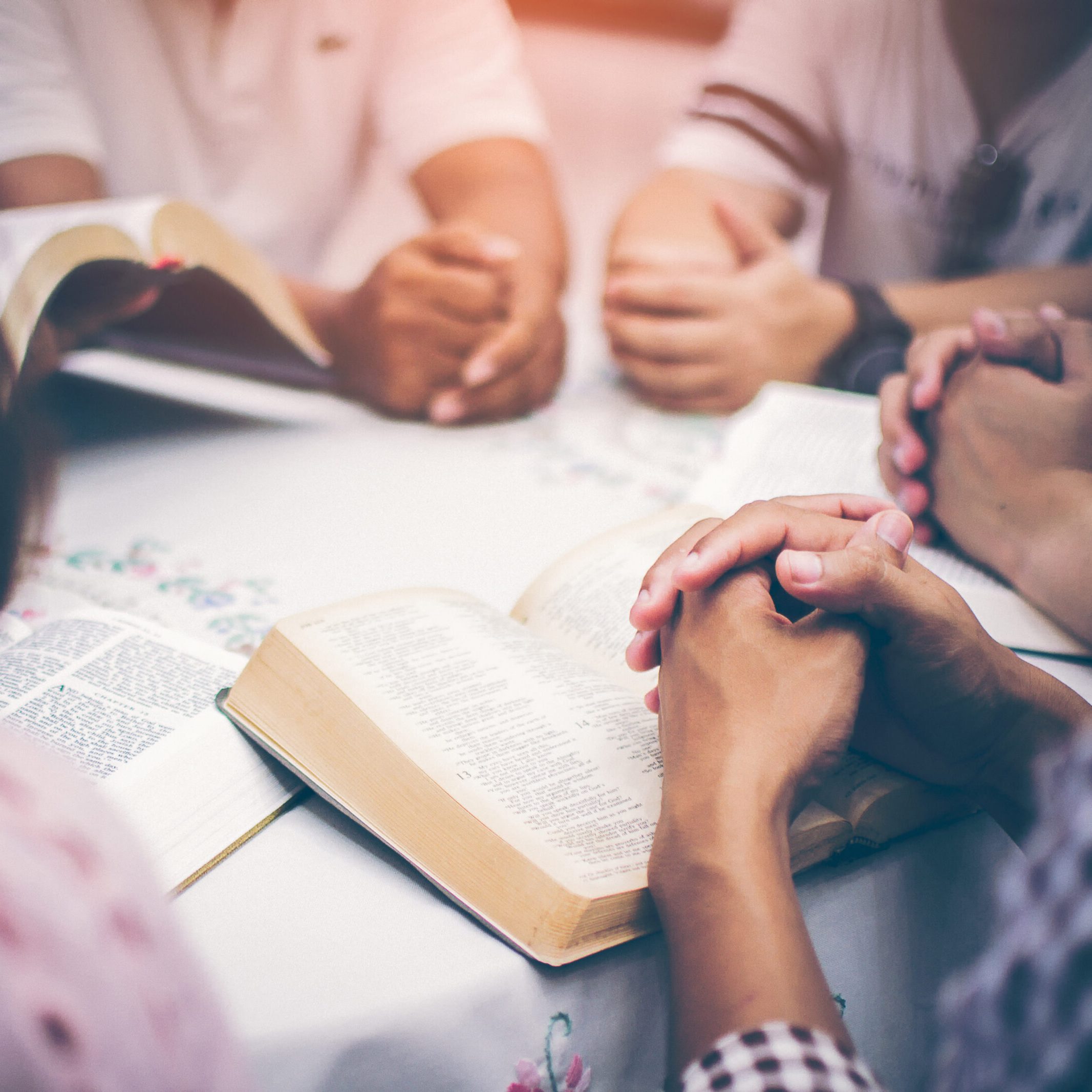 Christians are congregants join hands to pray and seek the blessings of God, the Holy Bible. They were reading the Bible and sharing the gospel with copy space.